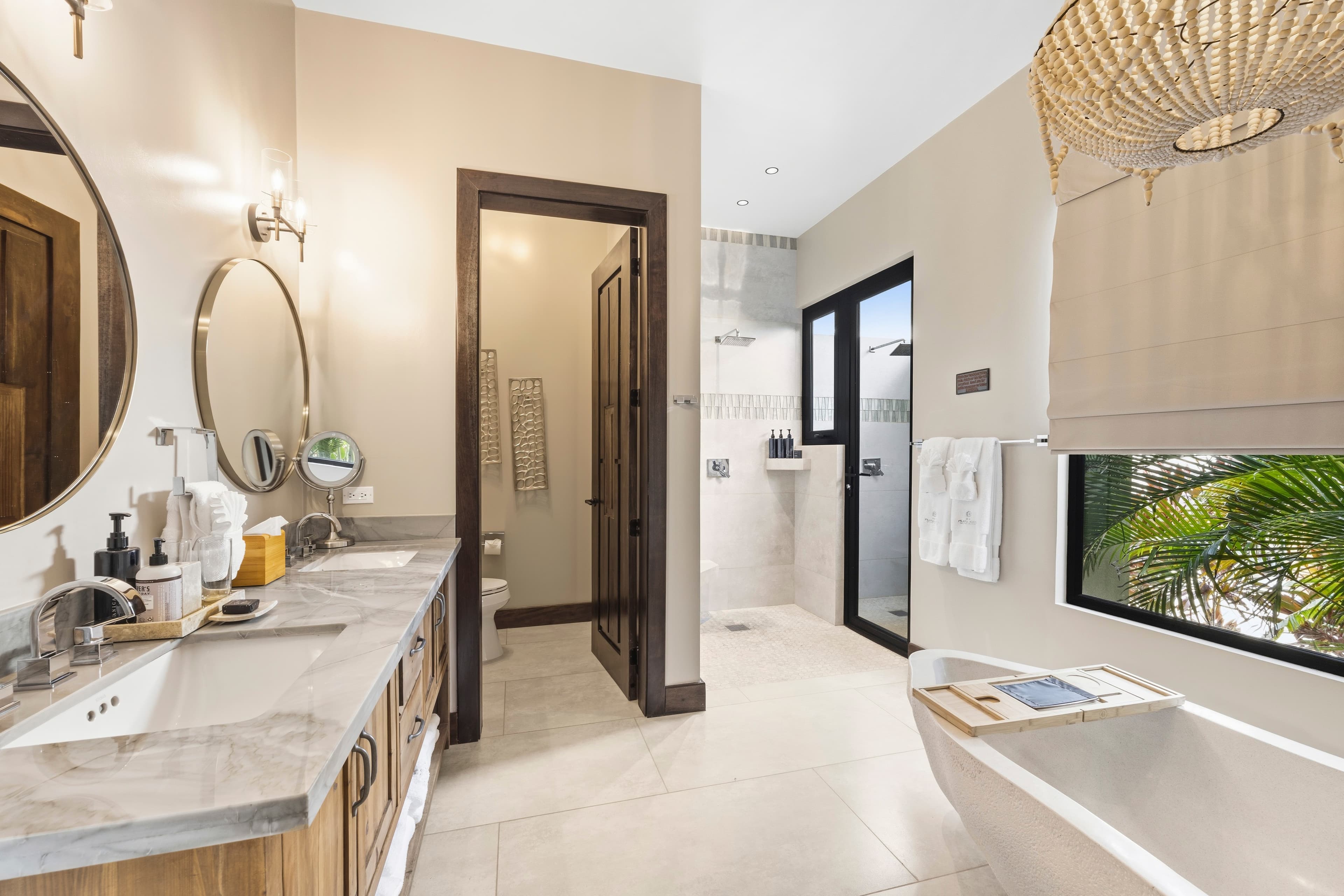A modern bathroom featuring a freestanding bathtub, double vanity, and large windows letting in natural light.