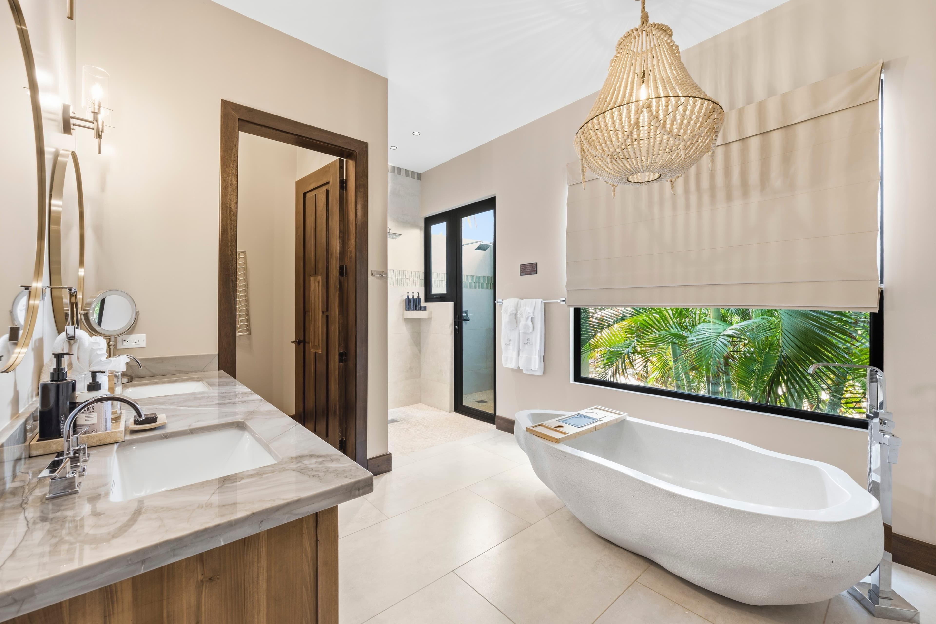 Modern bathroom featuring a freestanding tub, double sink vanity, and natural light from a large window.