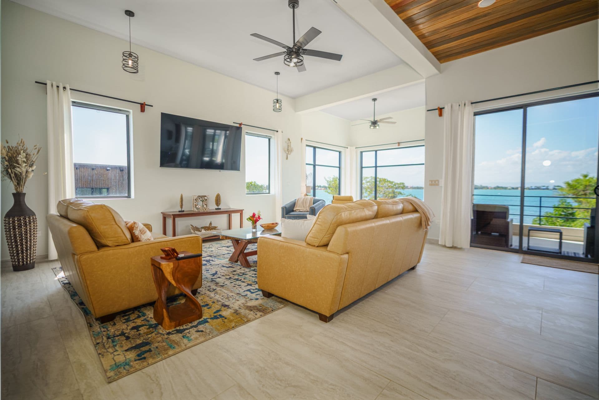Cozy living room with two sofas, a coffee table, and large windows showcasing a waterfront view.