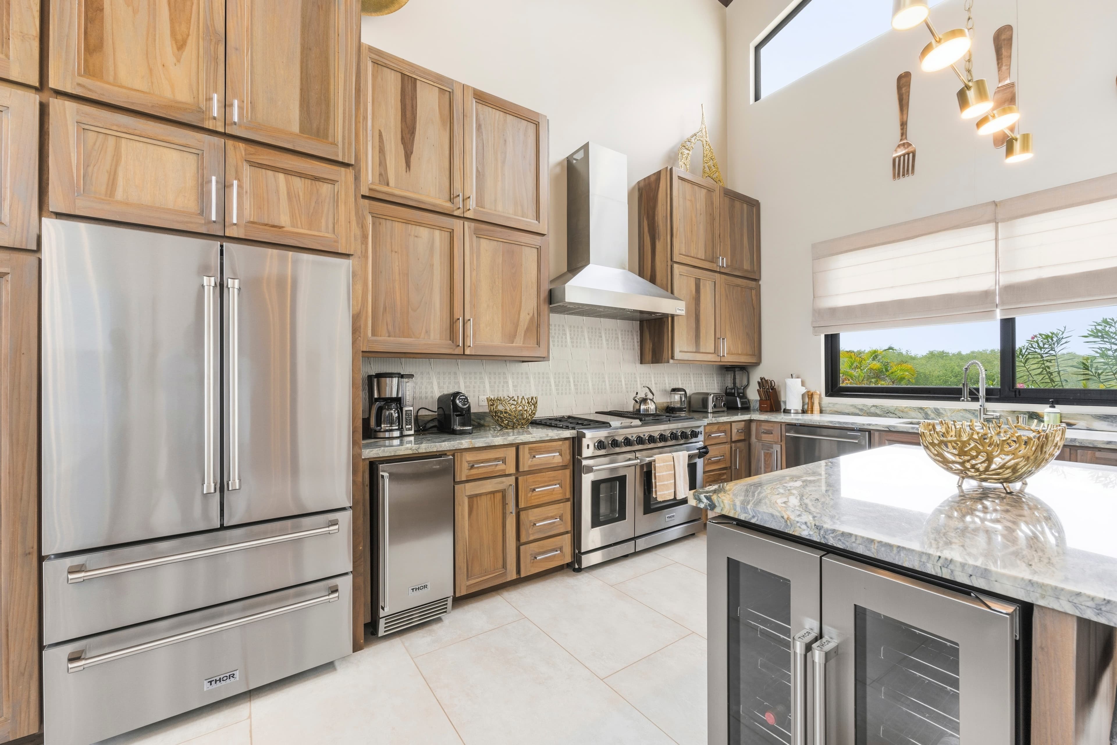 Modern kitchen featuring stainless steel appliances, wooden cabinetry, and a granite countertop.