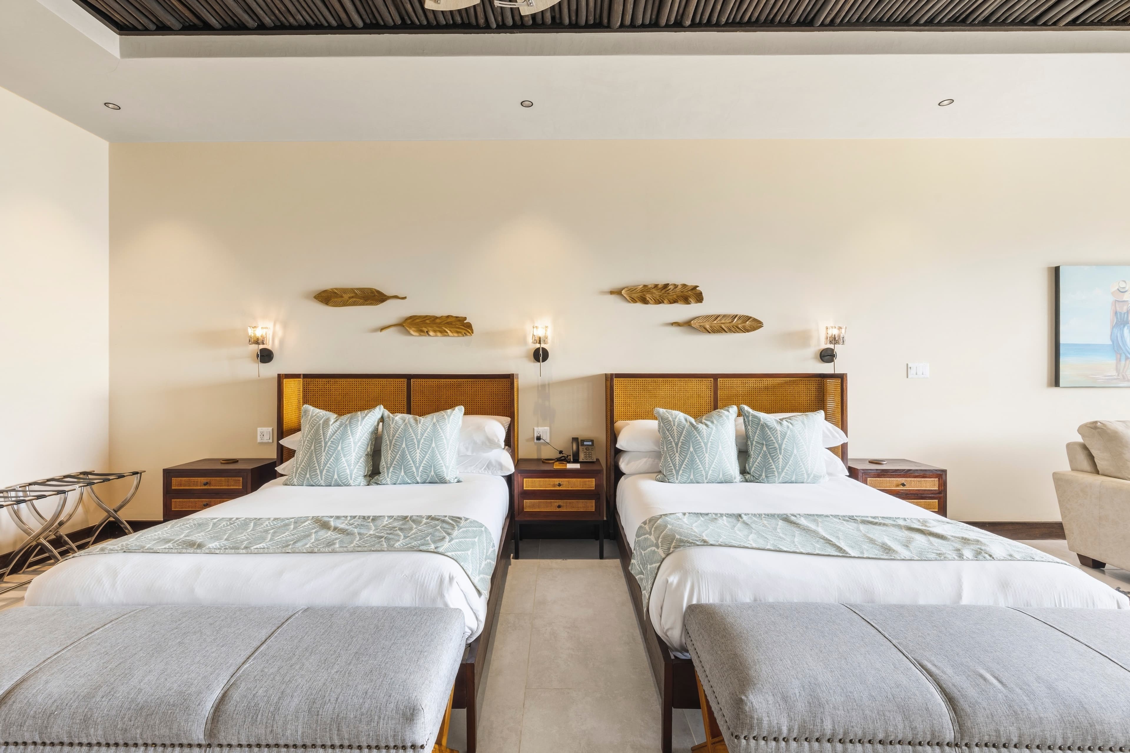 A modern hotel room featuring two twin beds, decorative wall art, and stylish furnishings.