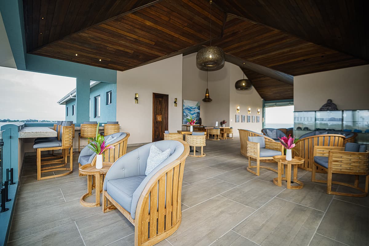 Modern outdoor seating area with wooden chairs and a decorated ceiling.