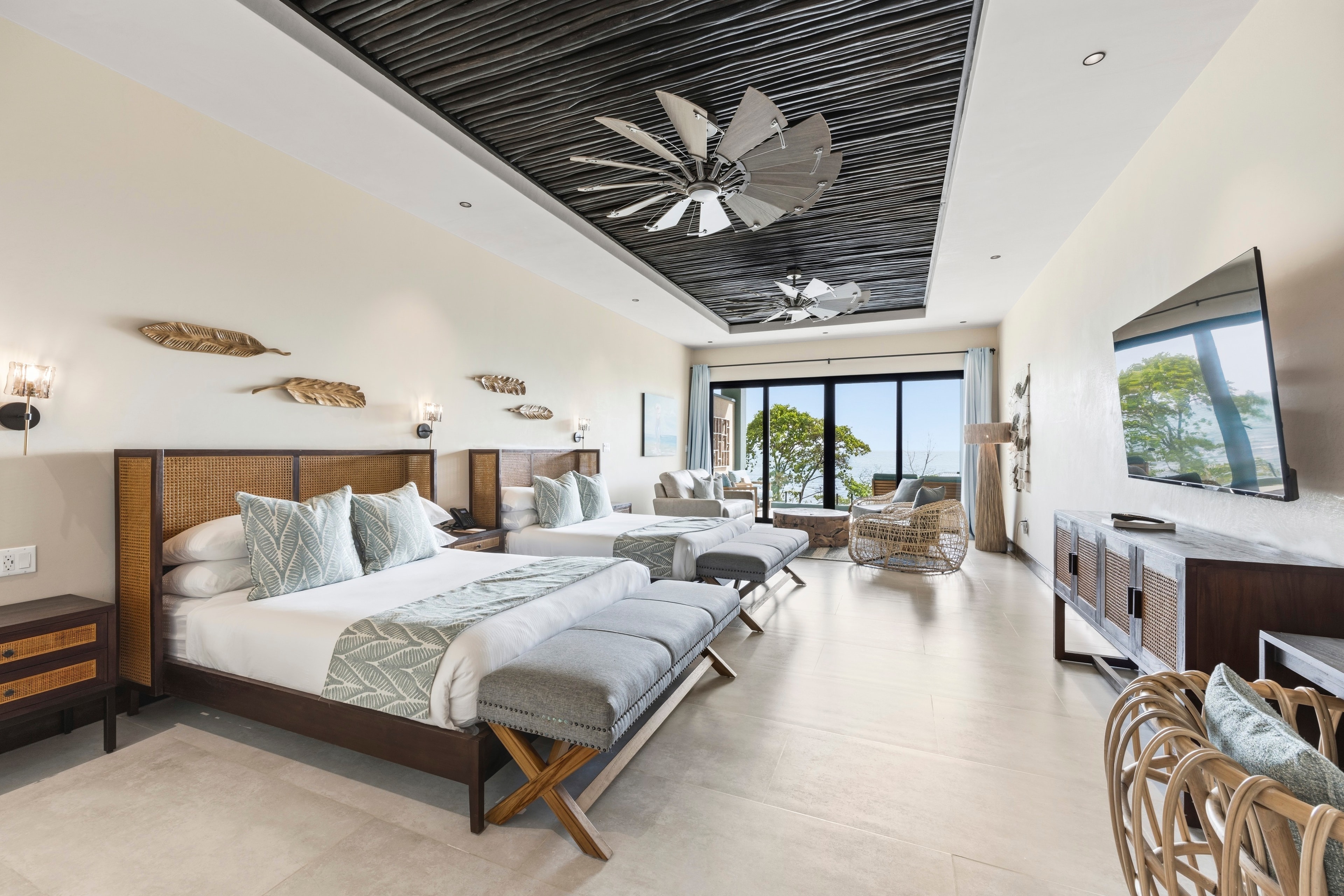 A spacious and modern hotel room with two beds, stylish decor, and large windows overlooking a scenic view.