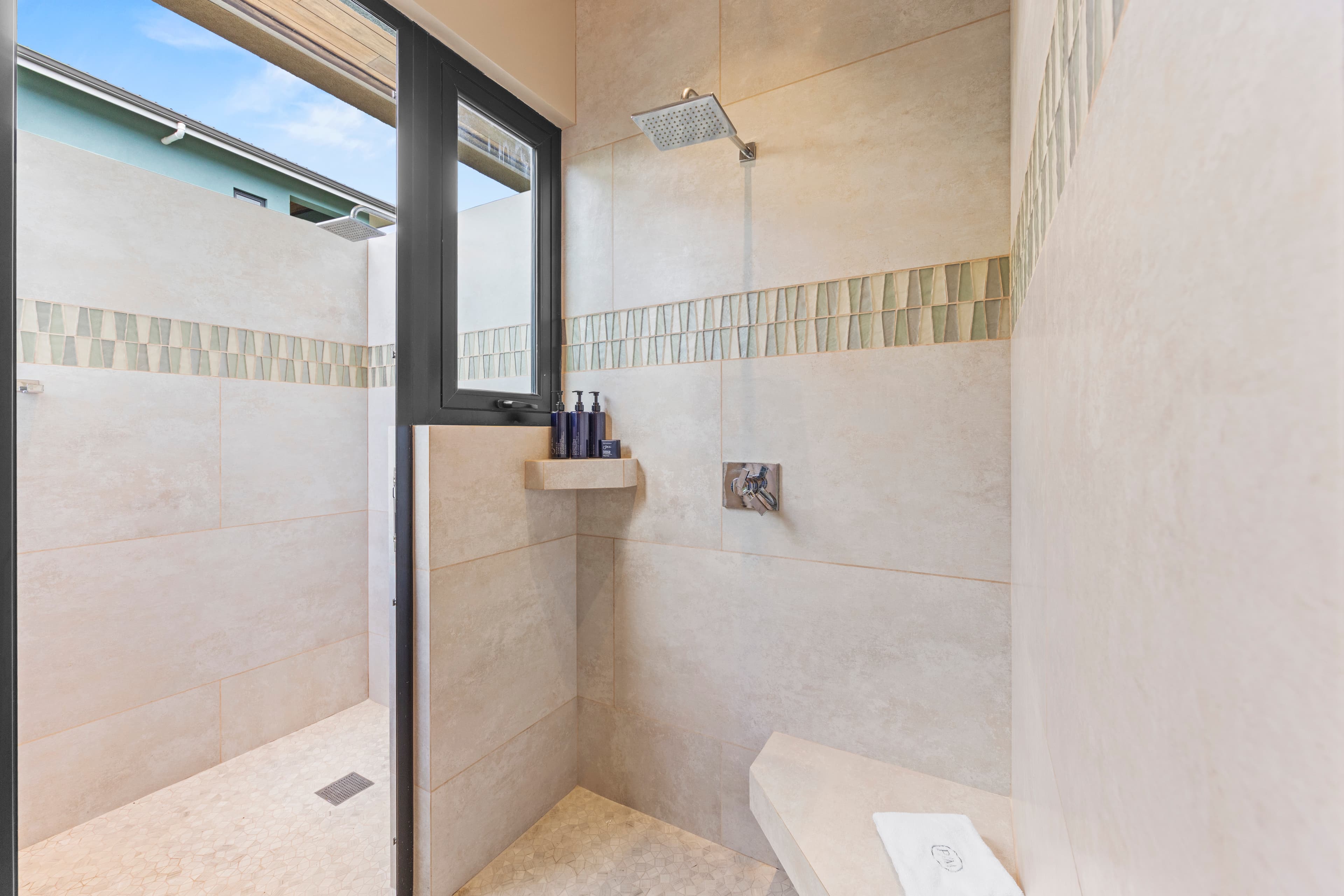 Modern shower space with natural light and decorative tile accents.