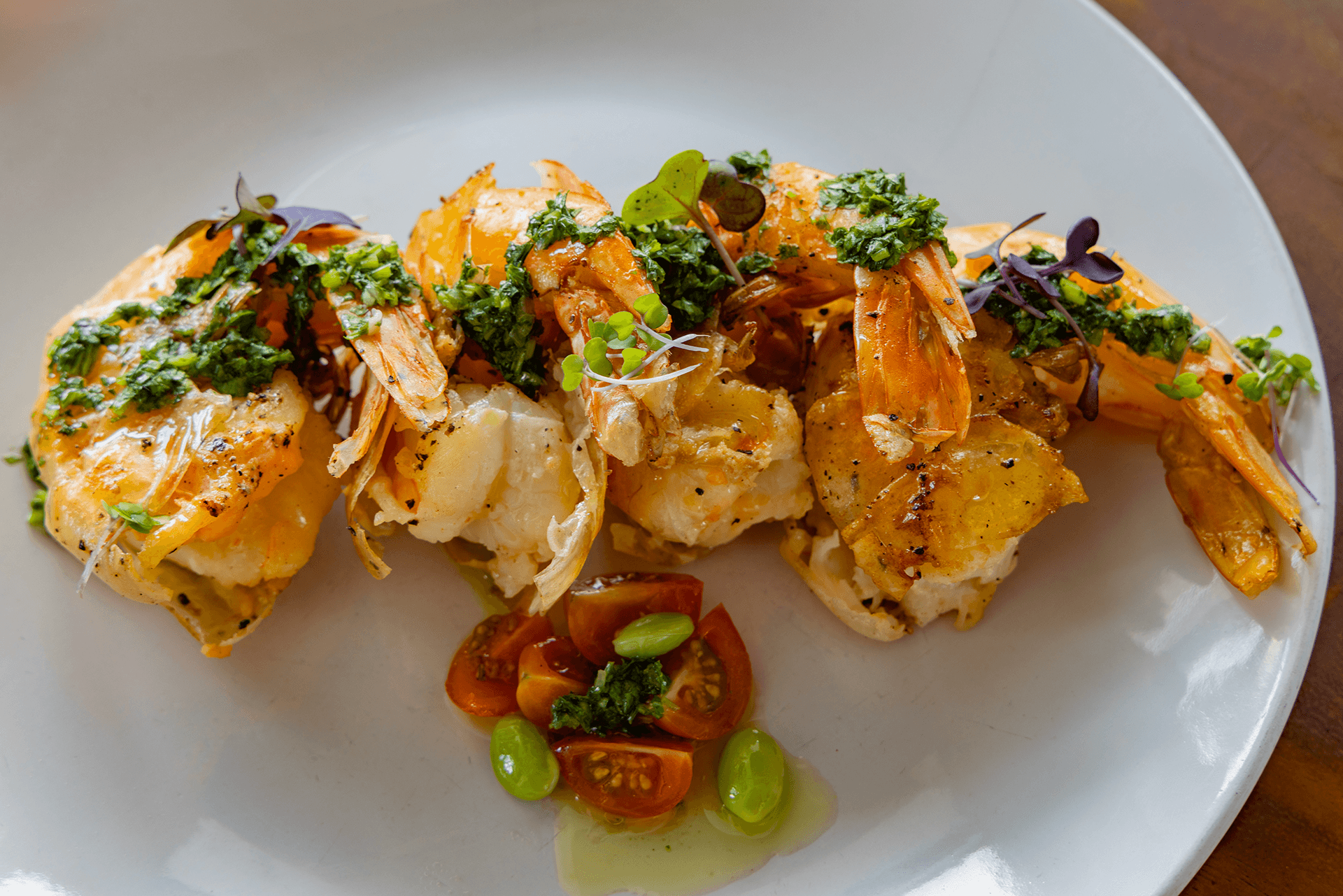 Grilled shrimp topped with herbs and served with cherry tomatoes.