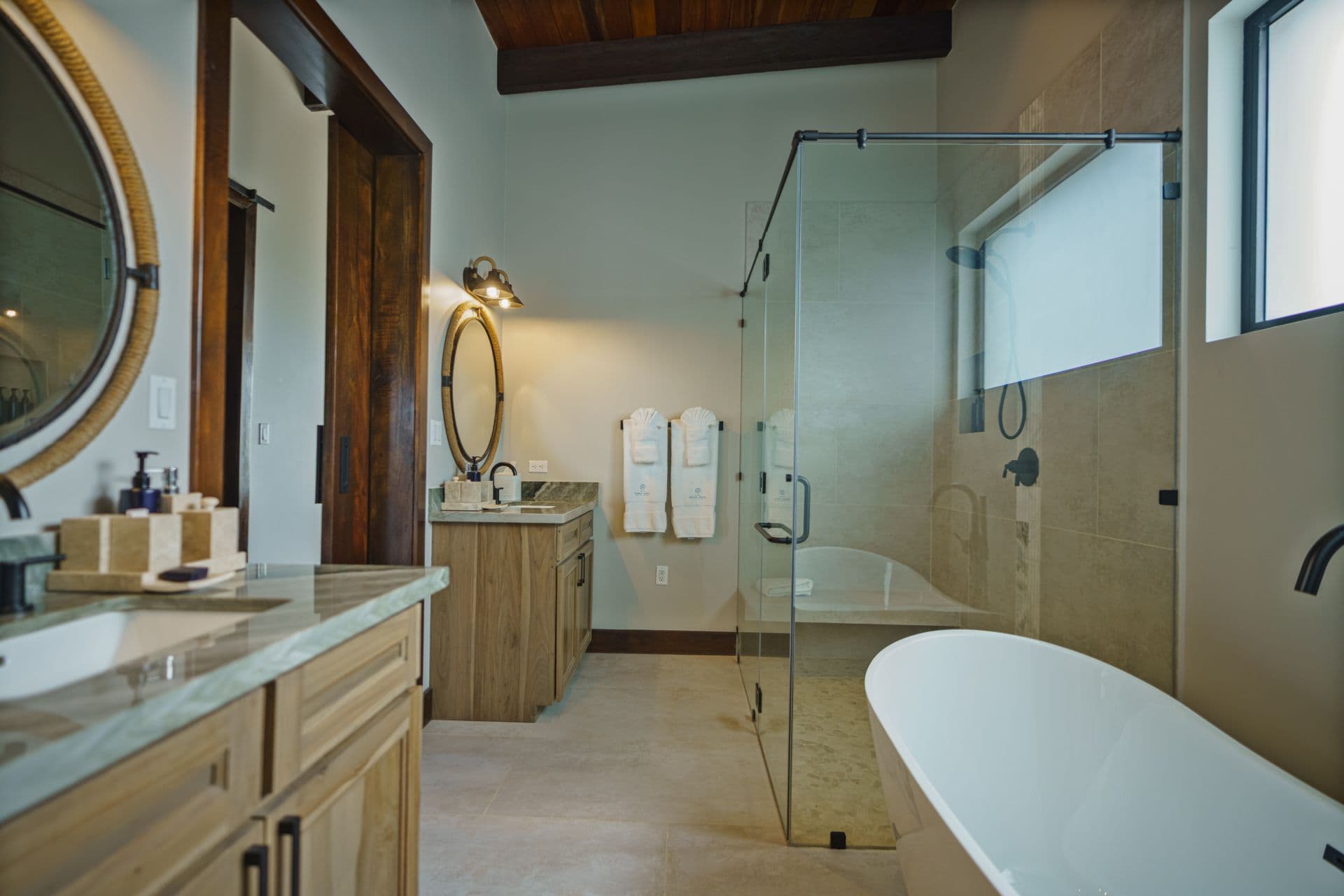 Modern bathroom featuring a freestanding tub, glass shower, and wooden accents.