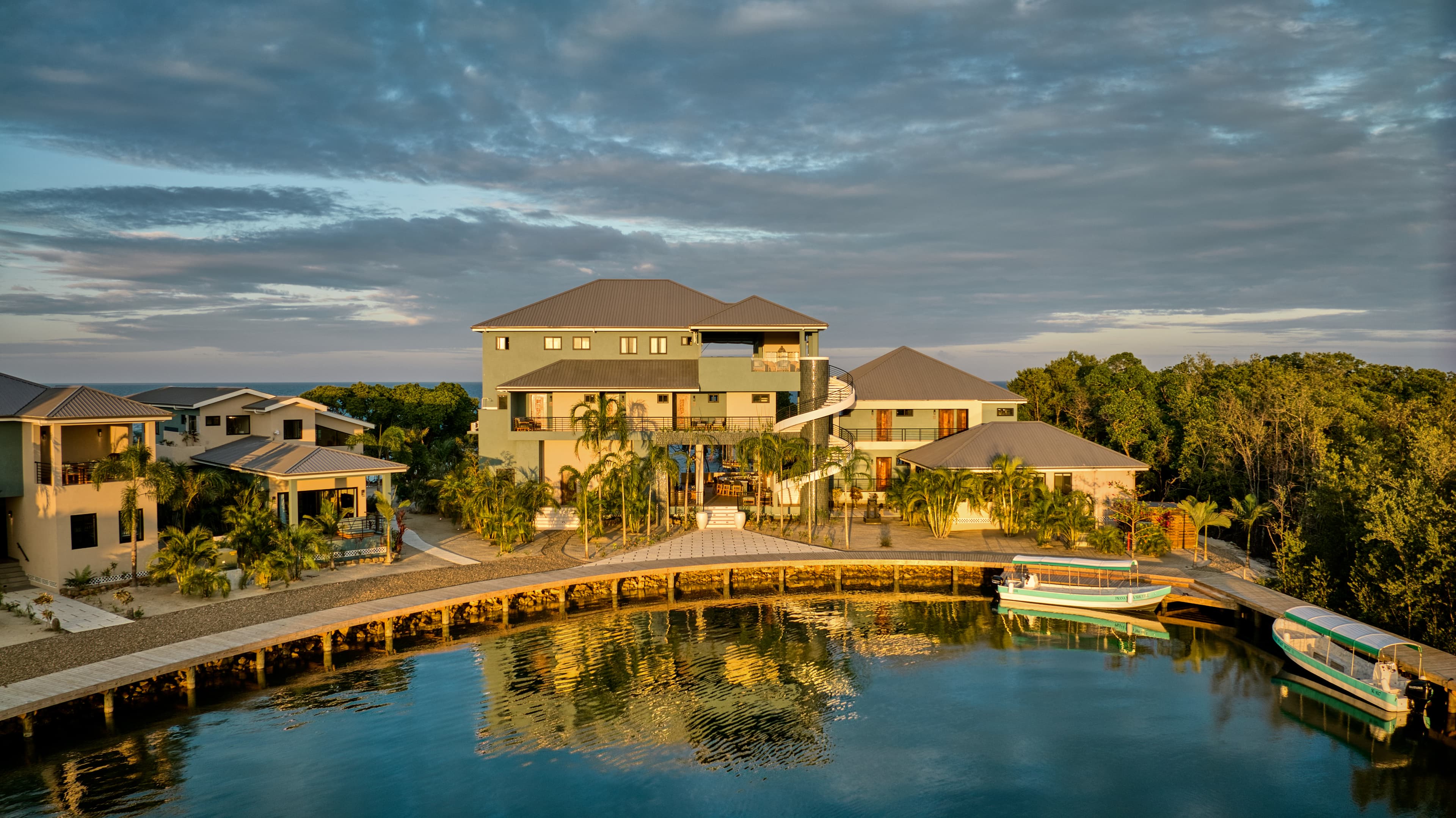 A modern waterfront resort with multiple buildings and boats docked along a serene waterway.