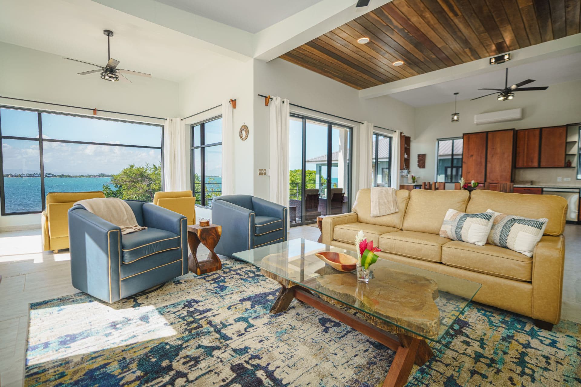 Bright, modern living room with seating, a coffee table, and views of the water.